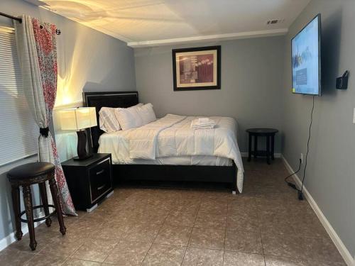 a bedroom with a bed and two tables in it at Luxury 2-Bedrooms 2-Bathrooms Near NYC/EWR in Newark