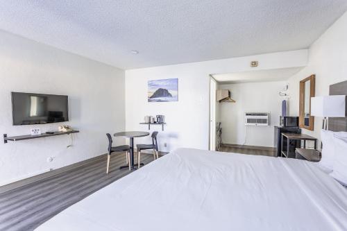 una camera da letto con un grande letto bianco e un tavolo di Coastal Breeze Inn a Morro Bay