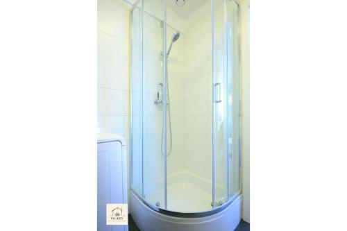 a shower with a glass door in a bathroom at VOKEY Studio 06 - City Center in Sopot