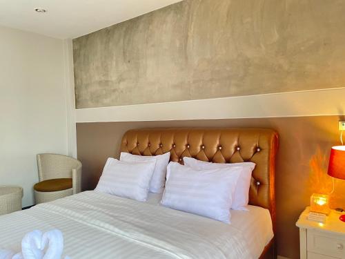 1 dormitorio con 1 cama grande con almohadas blancas en Smaids Room en Lampang