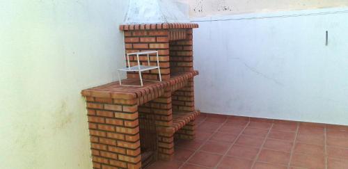 a brick fireplace with a shelf on top of it at One bedroom appartement with city view terrace and wifi at Serra d' El Rei in Serra de El-Rei