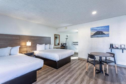 a hotel room with two beds and a table at Coastal Breeze Inn in Morro Bay