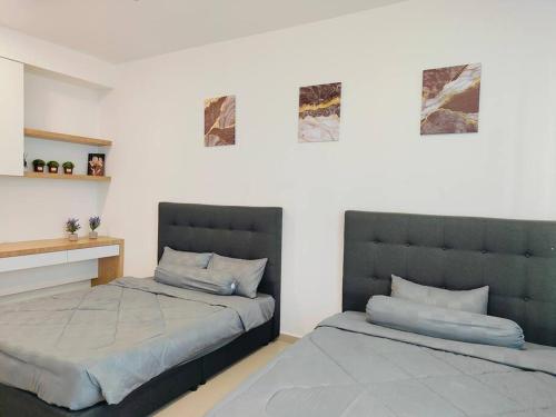 马六甲Una Cozy House Near Jonker and Heritage的卧室里有两张并排的床