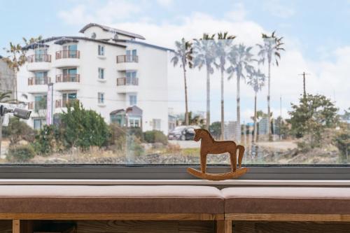 a wooden dog toy sitting on a window sill at Ddosi Aewol Pool Villa in Jeju
