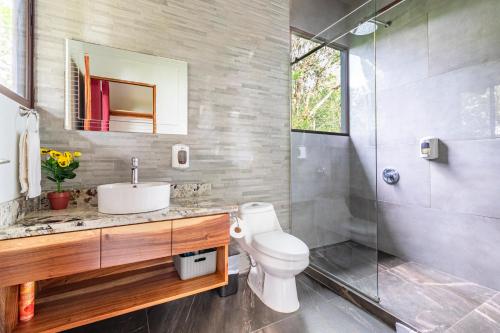 a bathroom with a toilet and a sink and a shower at Cougar Monteverde in Monteverde Costa Rica