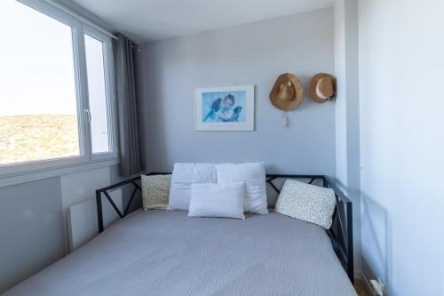 une chambre avec un lit avec des oreillers et une fenêtre dans l'établissement Appartement spacieux avec vue panoramique, à Cassis