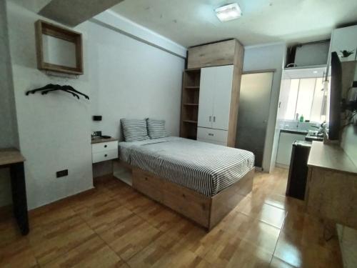 a bedroom with a large bed and a kitchen at Apartamento estándar en Lima Centro in Lima