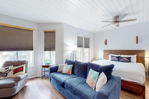 sala de estar con sofá azul y cama en Starfish, en Padre Island