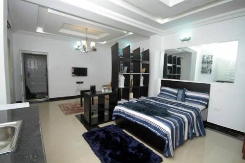 a bedroom with a bed and a desk in it at Jovini in Abuja