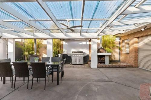 a patio with a table and chairs and a stove at Beachside SandDunes Villa Waterslide Gas Heat Pool in Tootgarook