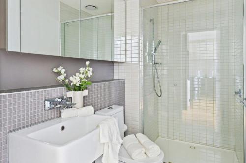 y baño con lavabo, aseo y ducha. en A Comfy 2BR Apt w City Views Near Southern Cross en Melbourne