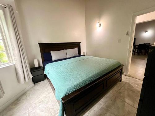 a bedroom with a bed with a green comforter at Crosbies Cabins Large Modern Space in Cedar Grove