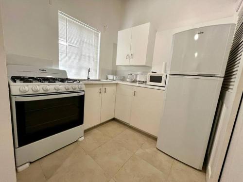 a kitchen with white cabinets and a stove and refrigerator at Large Modern Space in Cedar Grove