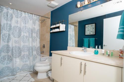 Baño azul con aseo y lavamanos en Coconut Grove Gorgeous Bay View 1 bedroom Condo Includes Parking, en Miami