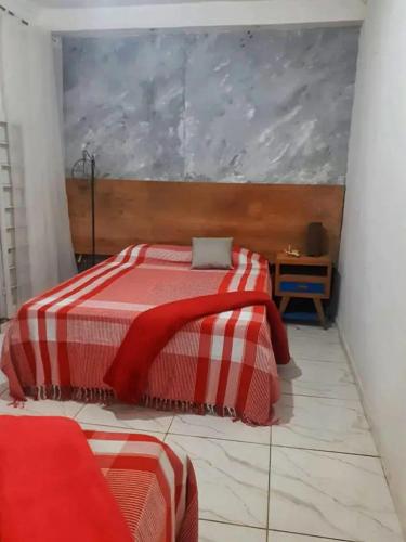 - une chambre dotée d'un lit avec une couverture rouge et blanche dans l'établissement Vilarejo do aconchego, à Santa Cruz de Minas