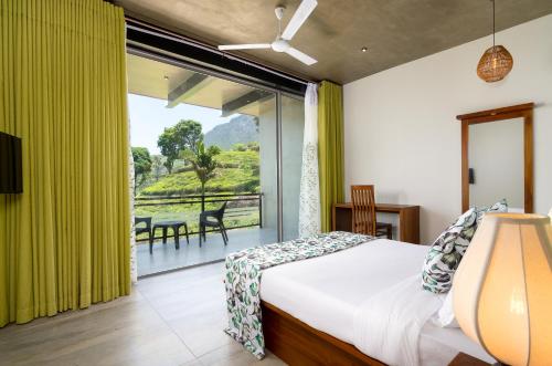 a bedroom with a bed and a large window at Tara Waterfall in Rakwana