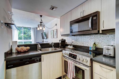 a kitchen with a sink and a stove top oven at Cute 1 bedroom unit located in Condo Hotel in the heart of Coconut Grove Free Parking in Miami