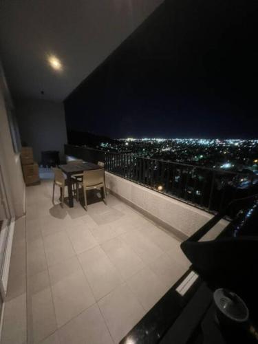 een balkon met een tafel en uitzicht op de stad bij Apartamento Mirador Lo Campino in Santiago
