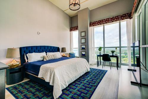 Schlafzimmer mit einem blauen Bett und einem Schreibtisch in der Unterkunft Luxury 2-story Penthouse located in Coconut Grove Hotel-includes Parking in Miami