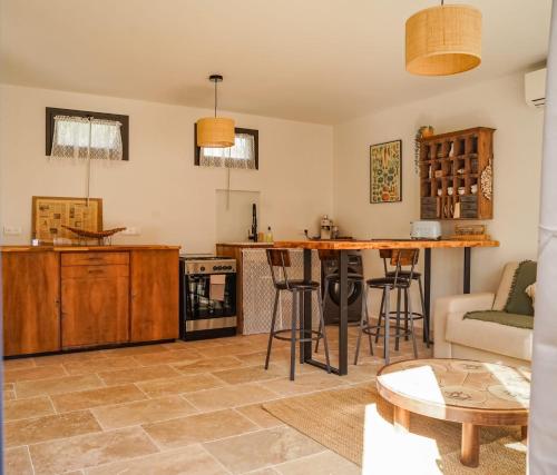 a living room with a table and a kitchen at Maison 47m2 à 10min des plages - billard, baby, salle de sport, jardin in Ajaccio
