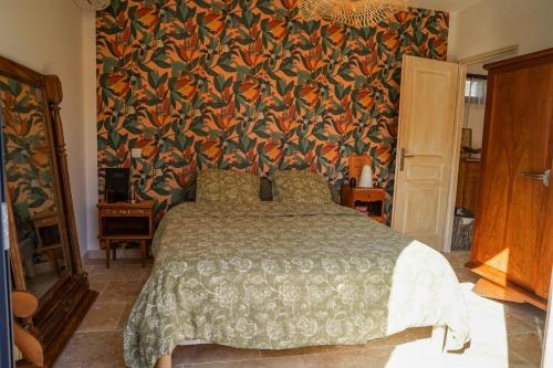a bedroom with a bed with a floral wallpaper at Maison 47m2 à 10min des plages - billard, baby, salle de sport, jardin in Ajaccio