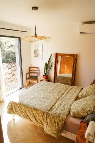 une chambre avec un lit et une plante en pot dans l'établissement Maison 47m2 à 10min des plages - billard, baby, salle de sport, jardin, à Ajaccio