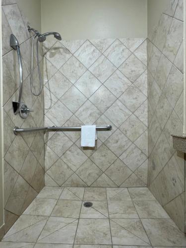 a bathroom with a shower with a towel at Spark Suites Hobby Airport in Houston