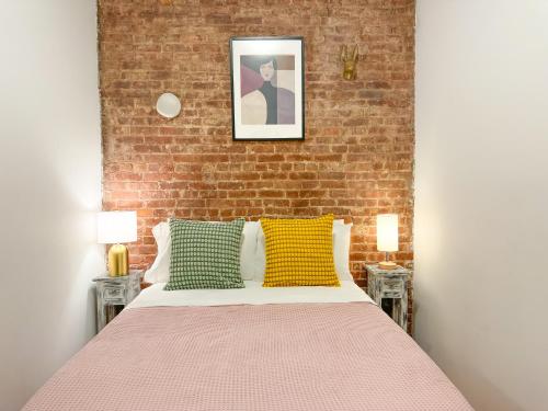 ein Schlafzimmer mit einem Bett und einer Ziegelwand in der Unterkunft 1727-1RN 1Br with A shared Patio - UES in New York