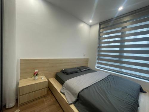 een slaapkamer met een bed en een groot raam bij MinA Home in Xóm Niêm