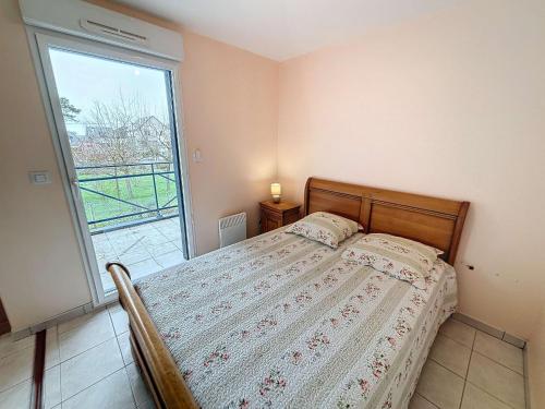 une chambre avec un lit et une grande fenêtre dans l'établissement Appartement avec parking à 250m de la plage, proche commerces - FR-1-361-120, à Jullouville