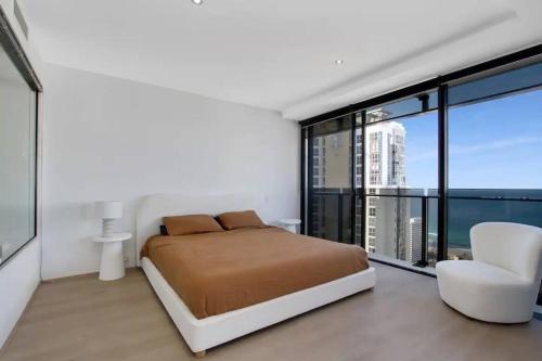 - une chambre avec un lit et une grande fenêtre dans l'établissement NEW! - Circle On Caville 33rd Floor Apartment Ocean Views, à Gold Coast