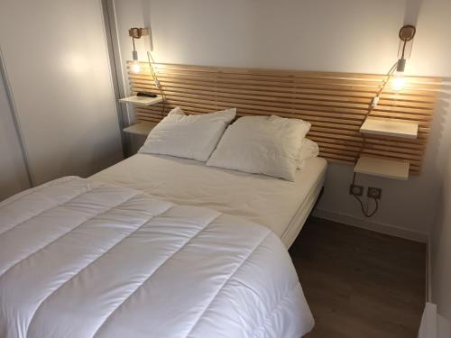 a bedroom with a white bed with two lamps on it at Appartement Hendaye, 2 pièces, 4 personnes - FR-1-239-777 in Hendaye