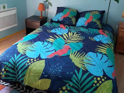 - un lit avec une couette bleue et des oiseaux dans l'établissement Appartement T3 avec Parking, Proche Centre et Plage - Arcachon - FR-1-319-492, à Arcachon