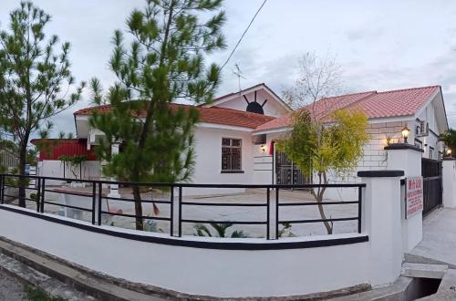 a white house with a fence in front of it at Pantai Remis Homestay 118A in Pantai Remis