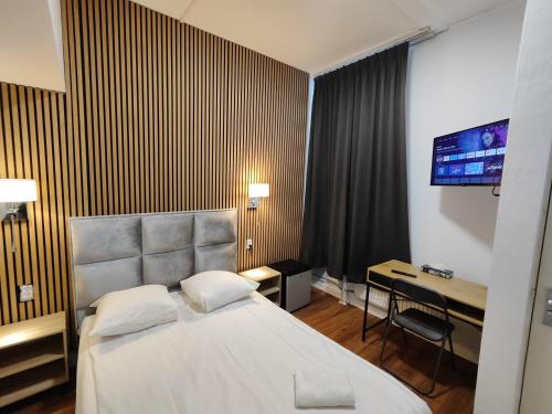 a hotel room with a bed and a desk at Hotel Holland Lodge in Utrecht