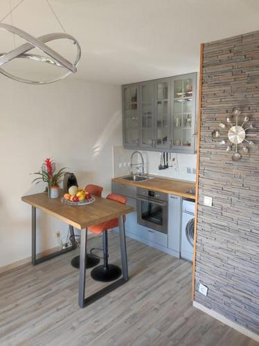 une cuisine avec une table avec un bol de fruits dessus dans l'établissement Petit lac appartement Mandelieu-la-Napoule, à Mandelieu-la-Napoule