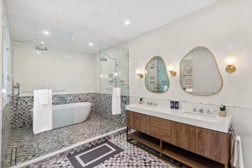 a bathroom with a tub and a sink and mirror at Riverside by Rove Travel 7BR Modern Townhouse in New York