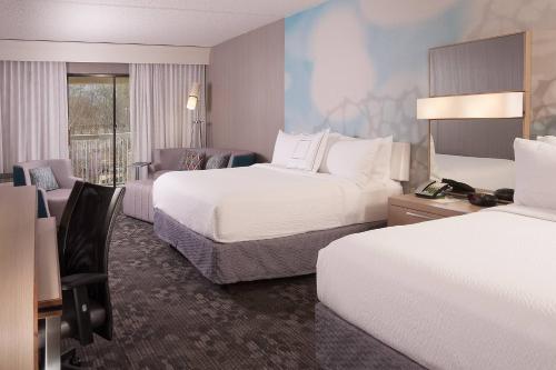 a hotel room with two beds and a desk at Courtyard Greenville-Spartanburg Airport in Greenville