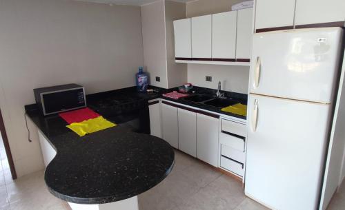 una piccola cucina con frigorifero bianco e tavolo nero di Apartamento en Tucacas a Tucacas