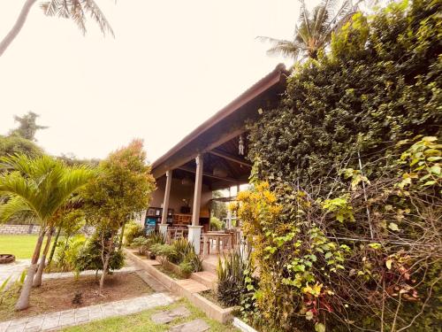 ペニダ島にあるPedidi Penida Hostelの茂みと木々が茂る建物