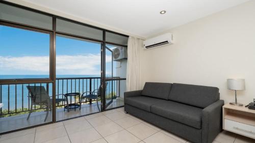 a living room with a couch and a balcony at Studio 811 - Picturesque Beachfront Views in North Ward