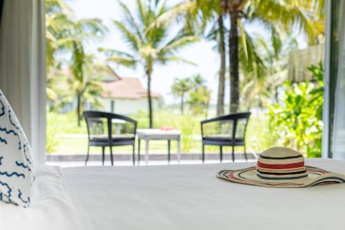 TUI BLUE Nam Hoi An Resort في تام كا: وجود قبعة على طاولة مطلة على الفناء