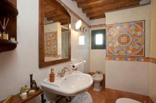 W łazience znajduje się umywalka, toaleta i lustro. w obiekcie Nettes Appartement in Mignana mit gemeinsamem Pool und Panoramablick w mieście Vinci