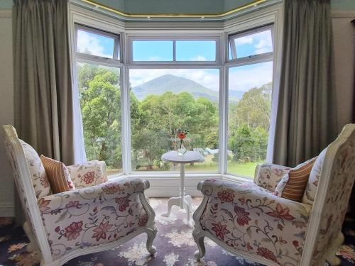 a room with two chairs and a large window at Rosebank Guesthouse in Healesville