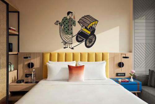 a bedroom with a bed with a painting on the wall at Hyatt Centric Ballygunge Kolkata in Kolkata