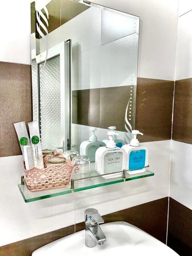 a bathroom with a mirror and a sink and a sink at OPA HOTEL HUE in Hue