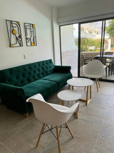 a living room with a green couch and two tables at TIZIANO RELAX 106 in Ricaurte