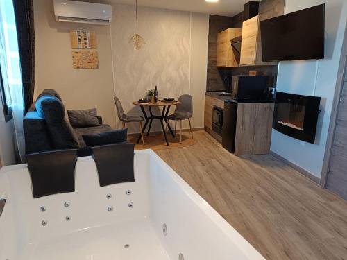 a living room with a bath tub and a table at Airen Suites in Chinchón