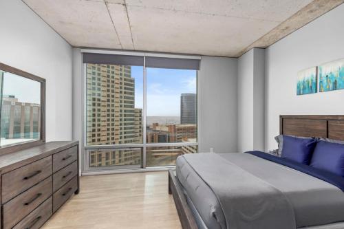 - une chambre avec un grand lit et une grande fenêtre dans l'établissement Luxury 2BR Penthouse in Downtown GR, à Grand Rapids