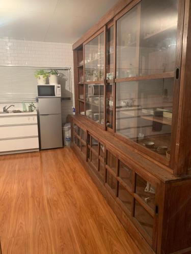 a kitchen with a large glass cabinet with a refrigerator at Myoko Casa in Myoko